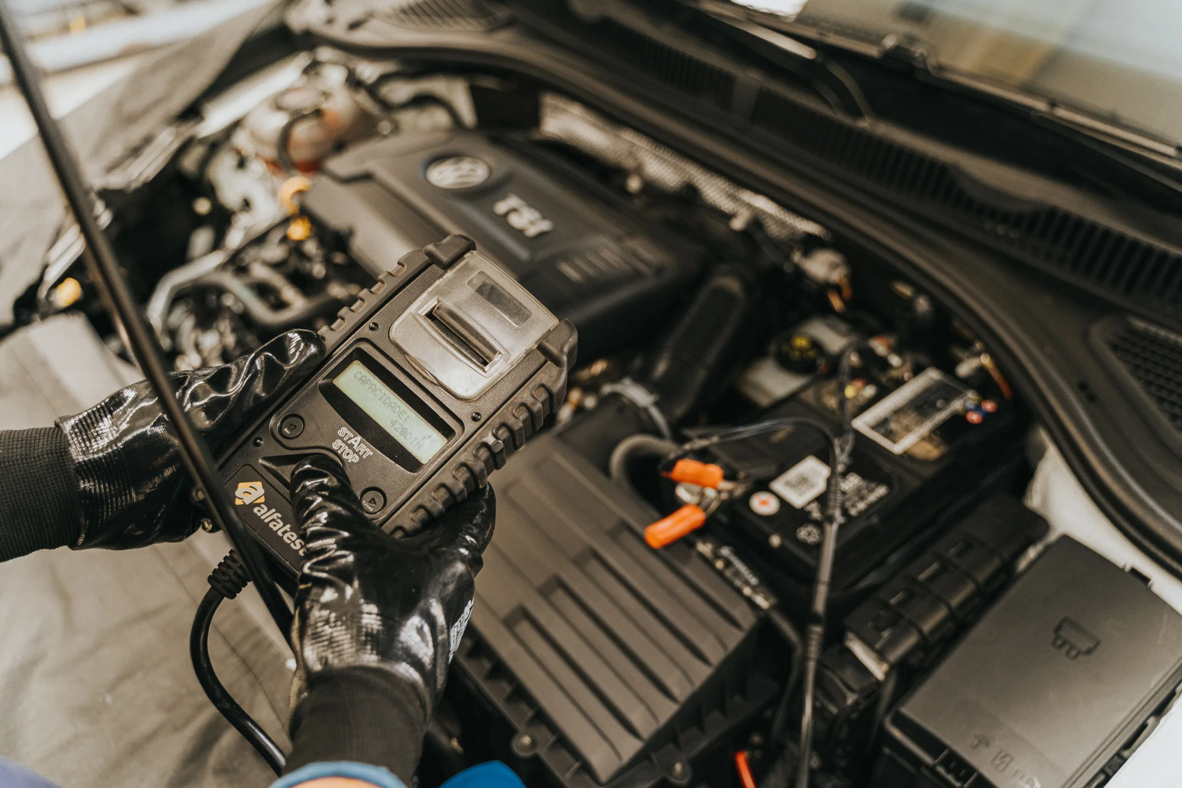 Mechanik používá diagnostické zařízení u motoru automobilu