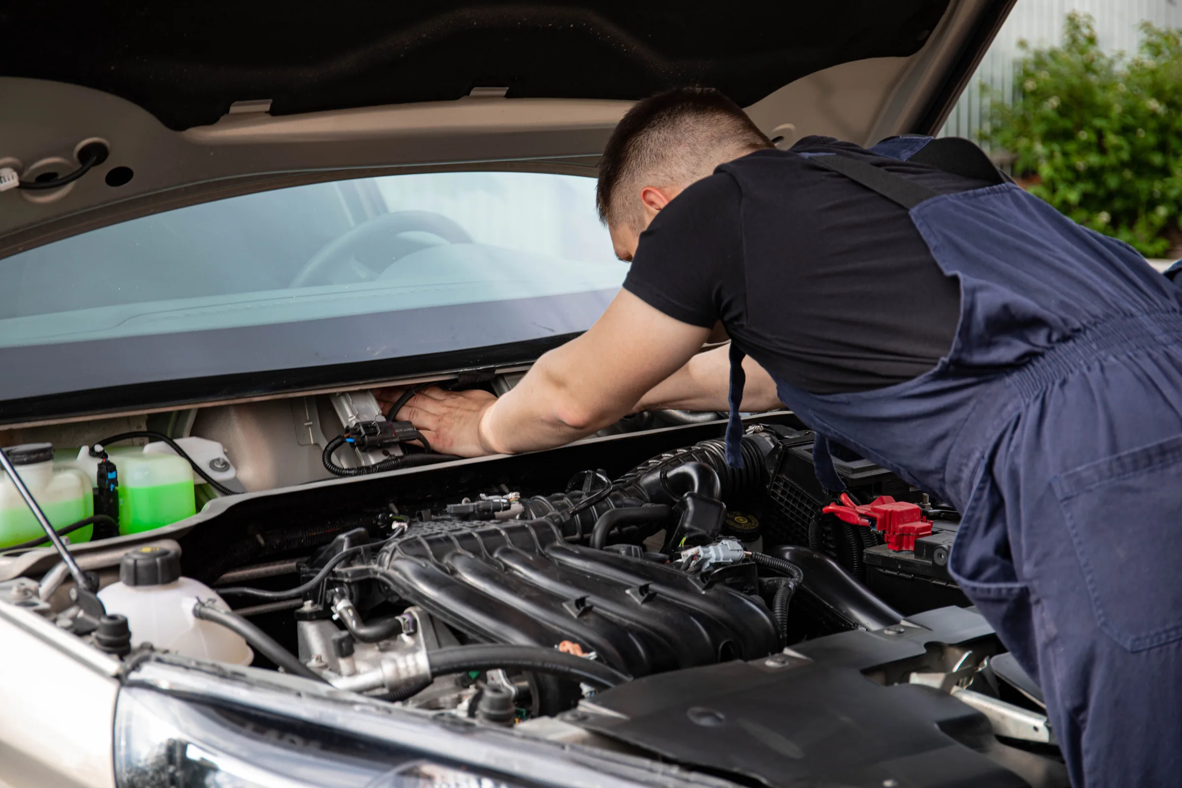 Mechanik pracuje u otevřeného motorového prostoru vozu